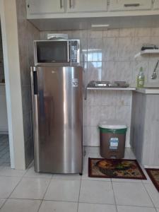 eine Küche mit einer Mikrowelle auf dem Kühlschrank in der Unterkunft Tranquility Place in Willemstad