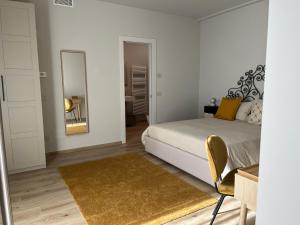 biała sypialnia z łóżkiem i lustrem w obiekcie Alba Room 16 w Albie