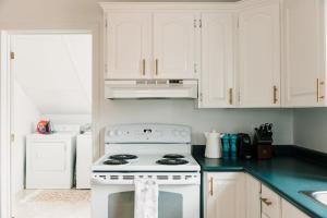 a kitchen with white cabinets and a white stove top oven at Town & Trail - Walkable Wellington Charmer ST-2021-0288 in Wellington