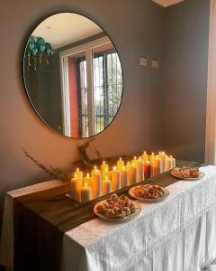 um grupo de velas sobre uma mesa em frente a um espelho em Sala dell Estate Guest House em Secchia