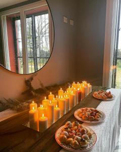 un groupe de bougies sur une table avec des assiettes de nourriture dans l'établissement Sala dell Estate Guest House, à Secchia