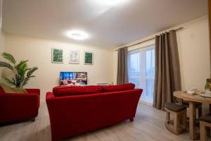 a living room with a red couch and a table at Cosy 2 Bedroom flat in Stevenage in Stevenage
