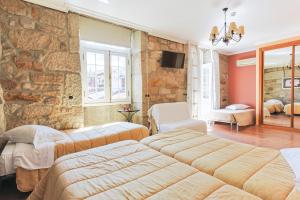 a bedroom with three beds and a stone wall at Residencial Bem Estar in Chaves