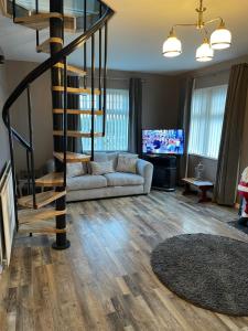 - un salon avec un canapé et un escalier en colimaçon dans l'établissement Carrick Lodge Mourne Mountains, à Newry