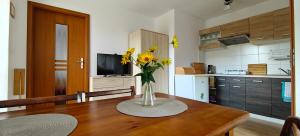 a kitchen with a table with a vase of flowers on it at pokoje wypoczynkowe "Róża" in Supraśl