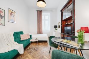 uma sala de estar com um sofá verde e uma mesa em Royal Style Apartment em Lódź