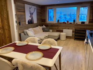 een woonkamer met een tafel en een bank bij 1650 Moriond - 2 Double Bedroom near Snow Front in Courchevel