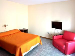 1 dormitorio con 1 cama y 1 silla roja en Casa Mar de Cobo EL PARAISO en Mar de Cobo