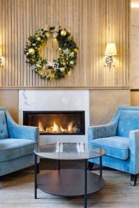 a living room with two blue couches and a fireplace at Hotel Port-Royal in Quebec City
