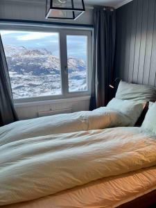 een slaapkamer met een bed en uitzicht op een berg bij Skarsnuten Panorama 46 in Grøndalen