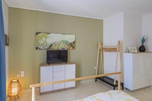 a bedroom with a bed and a tv on a wall at Seaside Apartment in Salamís