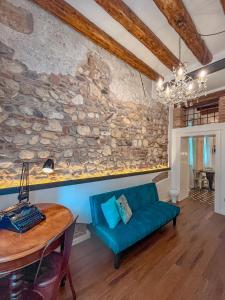 un soggiorno con parete in pietra e divano blu di Appartamento al Teatro Romano a Verona
