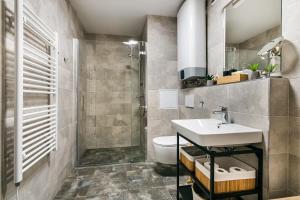a bathroom with a sink and a shower and a toilet at Apartman Mikulov Garden in Mikulov