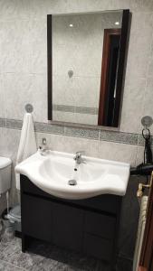 y baño con lavabo blanco y espejo. en Vista Triunfo, en Granada