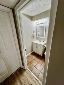 a bathroom with a sink and a toilet and a door at Cozy 2BR in Alexandria, VA in Alexandria