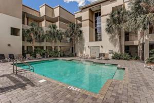 a swimming pool in front of a building with palm trees at Comfort and Style at AIP Resort in Amelia Island