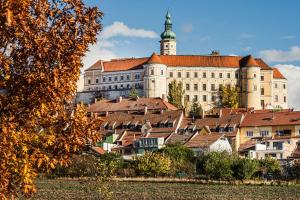 a large building with a tower on top of a town at Apartman Mikulov Garden in Mikulov