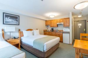 a hotel room with two beds and a kitchen at Sundance Lodge in Sun Peaks