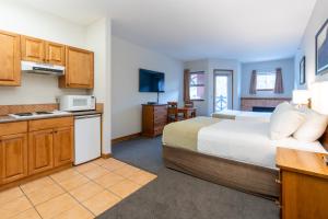 a hotel room with a bed and a kitchen at Sundance Lodge in Sun Peaks