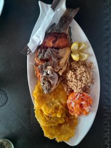 Mi Cabañita Guest House في بلايا بلانكا: طبق من الطعام مع لحم ورز على طاولة