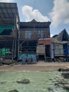 Mi Cabañita Guest House في بلايا بلانكا: مبنى على الشاطئ أمامه ماء