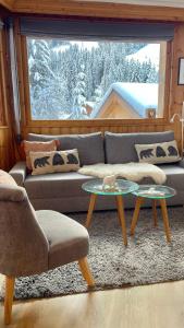 Meribel Centre La Chaudanne - ski in and out apartment - 3 bedrooms - 1 min to main ski lifts and 5 min to center of Meribel - newly renovated in Oct 2023 - Chalet l'Épervière في ميريبيل: غرفة معيشة مع أريكة وطاولتين