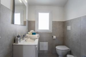 a bathroom with a sink and a toilet and a window at Casa Bijou in Pula +12 photos