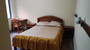 1 dormitorio con cama, escritorio y silla en The House Tarija, en Tarija