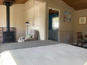 ein Schlafzimmer mit einem Bett, einem Stuhl und einem Kamin in der Unterkunft Jenner Inn in Jenner