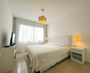 une chambre blanche avec un lit et une télévision dans l'établissement Emerald Apartments - Parrillero exclusivo, à Punta del Este 35 autres photos