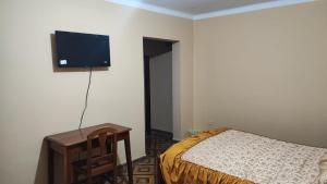 a bedroom with a bed and a flat screen tv on the wall at The House Tarija in Tarija