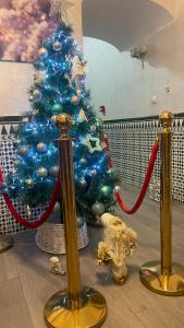 a blue christmas tree with a red and blue ribbon at Hotel Boutique Andalucia in Fuengirola