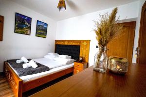 Un dormitorio con una cama y una mesa con un jarrón. en Apartamenty u Trebuniów en Suche