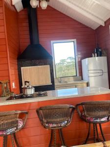uma cozinha com um balcão com um fogão e 3 cadeiras em Recanto do Noah em Painel