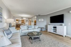 a living room with a couch and a tv at Oceanfront Elegance at AIP Resort in Amelia Island