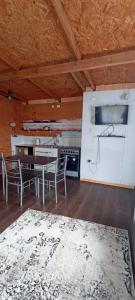 a kitchen with a table and chairs in a room at Cabañas La Cascada in Chaitén