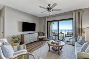 a living room with a couch and a tv at LUX Oceanfront Retreat at AIPResort in Amelia Island