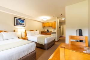 a hotel room with two beds and a kitchen at Sundance Lodge in Sun Peaks