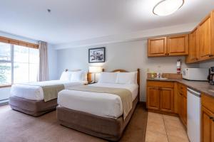 a hotel room with two beds and a kitchen at Sundance Lodge in Sun Peaks