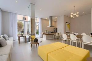 uma sala de estar com um sofá e um repousa-pés amarelo em Flat sensacional 4 pessoas em condomínio moderno 2 suites climatizados em São Paulo