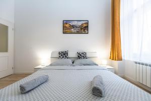a bedroom with a large white bed with two pillows at Stylish Apartment at Wenceslas Square in Prague