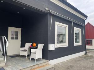 a black building with chairs and a table on a patio at Split 2 in Veberöd