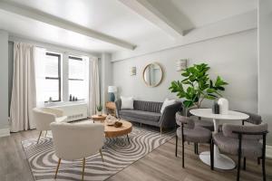 a living room with a couch and a table and chairs at 73-201 New 1BR 1Bth UWS Doorman Gym in New York