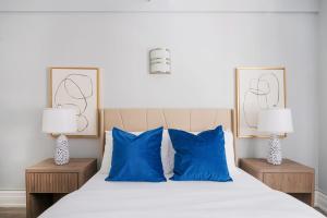- une chambre avec un lit doté d'oreillers bleus et de 2 lampes dans l'établissement 73-201 New 1BR 1Bth UWS Doorman Gym, à New York