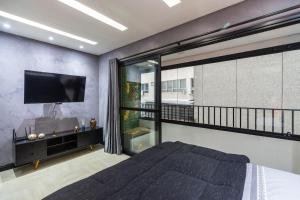 a bedroom with a bed and a flat screen tv at MY512 - Bela Vista - Studio Moderno "Próx. a Paulista" in Sao Paulo