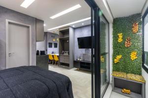 a bedroom with a bed and a tv and a kitchen at MY512 - Bela Vista - Studio Moderno "Próx. a Paulista" in Sao Paulo