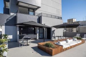 une terrasse avec des canapés, des tables et des parasols dans l'établissement MY512 - Bela Vista - Studio Moderno "Próx. a Paulista", à São Paulo