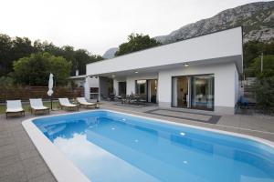 a villa with a swimming pool in front of a house at Holiday Home EB with Heated Pool in Gata