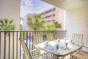 a balcony with a table and chairs on a balcony at 210 - Sandy Shores in St. Pete Beach