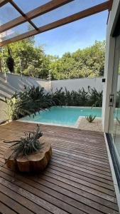 una terraza de madera con una piscina en el fondo en Casa alto padrão com piscina em Foz, en Foz do Iguaçu